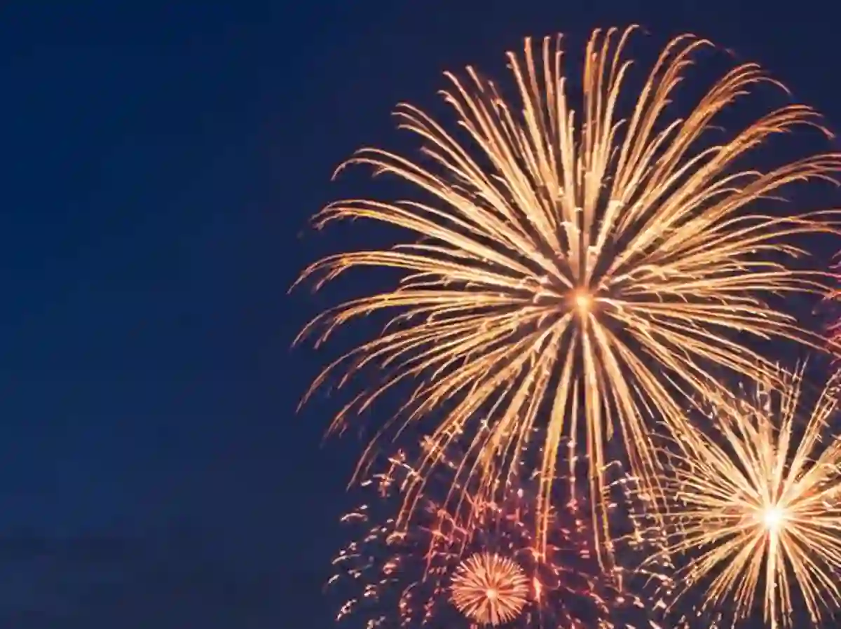 Gold and coral fireworks reflecting over Destin Harbor at night